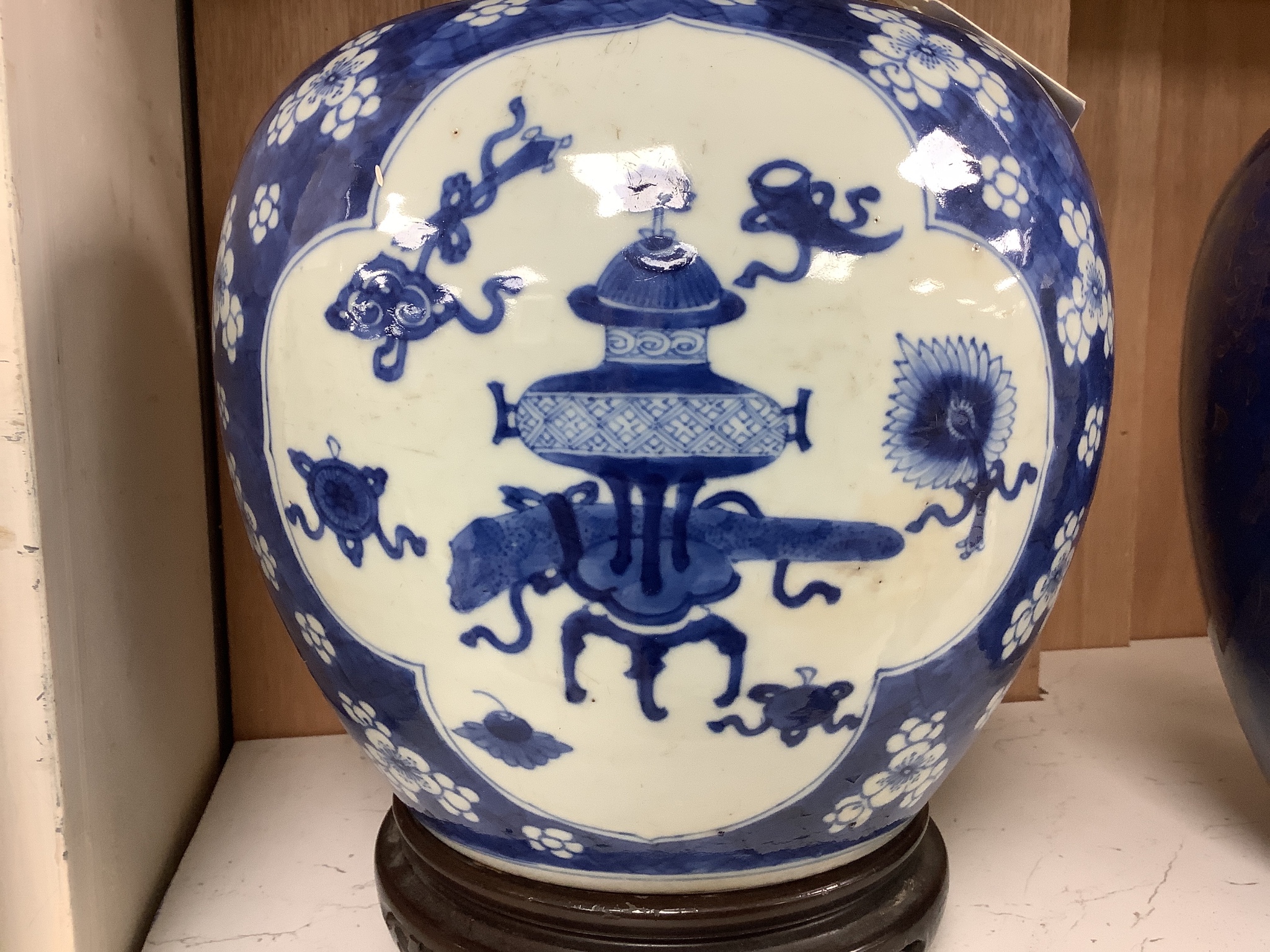 A Chinese Kangxi blue and white hundred antiques jar, 21cm, cracked, with hardwood stand and a Samson powder blue jar, 26cm, wear